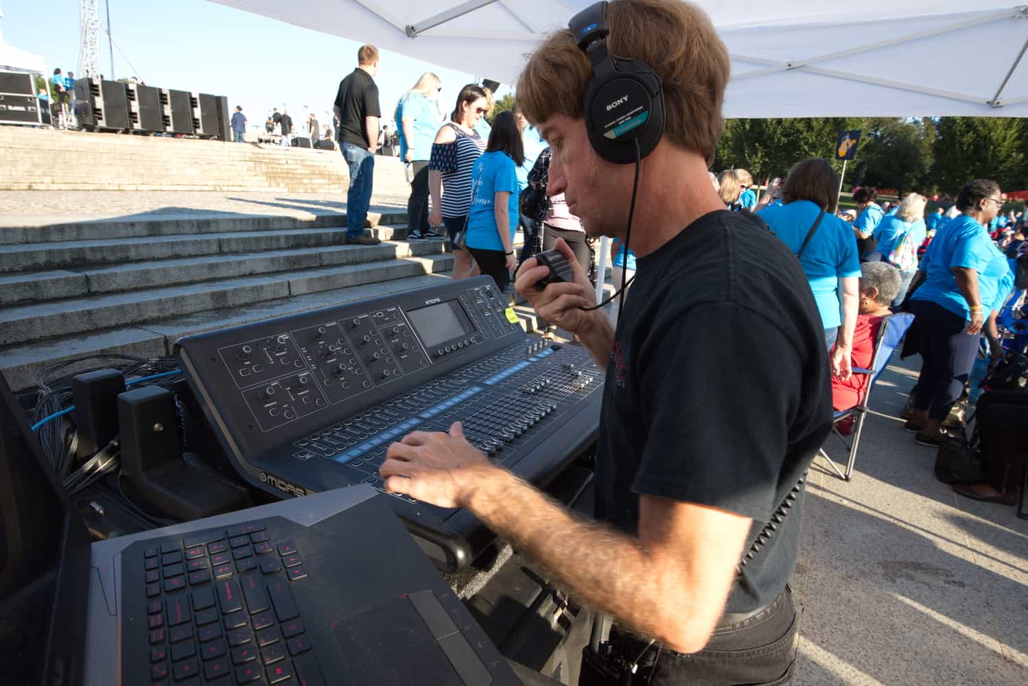 an A1 audio technician checking EQ levels on a digital mixing console during a soundcheck at and event.