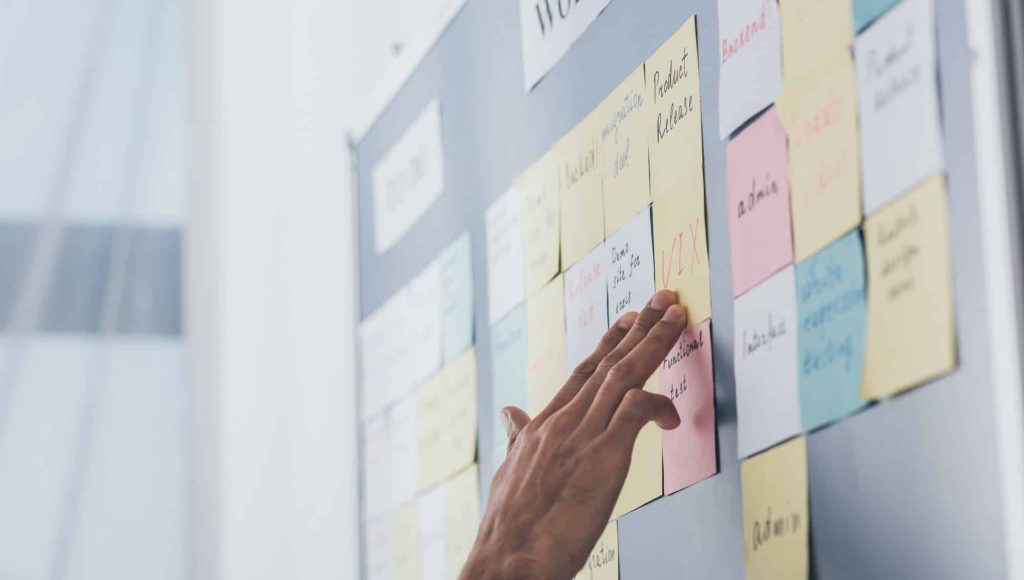 cropped view of businessman touching sticky notes with letters in office